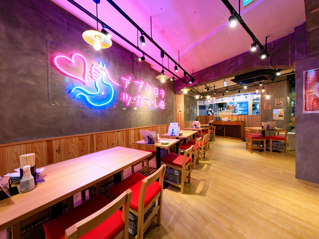 ピンクのネオンが映えるかわいい店内。1階と地下で132席をご用意