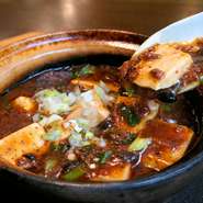 アツアツの状態でお召し上がりいただきたいという思いから土鍋でご提供させていただいている本格麻婆豆腐。4種類の豆板醤や花椒を使用することで、万人受けするバランスのとれた麻婆豆腐となりました。