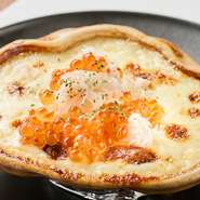 北海道産の蟹をふんだんに使った贅沢な蟹グラタン。蟹の甲羅をそのまま使った器に、蟹の風味たっぷりの濃厚なホワイトソースを乗せて焼き上げた逸品。紅と白のコントラストも印象的な一品です。