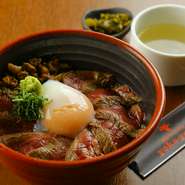 自社牧場で育てたあか牛を贅沢に使用した、その旨みを手軽に味わえる丼ぶりです。ミディアムレアに焼かれたあか牛ステーキのスライスが、ご飯の上に贅沢に敷き詰められています。