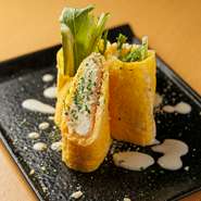 薄焼き卵で生ハムやクリームチーズを巻いた、見た目も華やかな一皿です。黄色・ピンク・白のコントラストに新鮮野菜の緑が加わり、味だけでなく彩りも抜群。串焼きを待つ間に、白ワインと一緒に楽しんで。