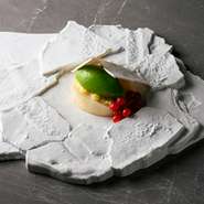 タイルのようなメレンゲを動かすと、旬のフルーツや食材が現れます。メレンゲで型取った特注の有田焼の器との一体感はまさに芸術。どこまで食べられるか、トリックアートのような要素も楽しめます。