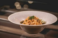 玉ねぎ・にんじん・セロリ・ニンニクなどの香味野菜をふんだんに使用した自家製トマトペーストで鶏肉を長時間煮込み、トマトの甘みと鶏肉の旨味、コクが詰まった鶏肉のトマト煮込みリゾットです。