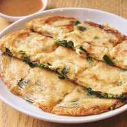 小麦粉の代わりに、豆腐のペーストを使い、ニンニクの芽、ニラ、豚肉などの具を混ぜたふわふわのチヂミです。バラバラにならないようライスペーパーの上に延ばし、その面をカリカリに焼いた食感がアクセントに。