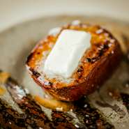 宮崎県のサツマイモ生産者が、収穫後、1ヶ月以上寝かせて糖度を高めてからじっくり火を入れて焼芋に。これを炭火焼きにした熱々の上にバターをのせて提供。きめ細かくねっとりとした食感の極上デザートです。