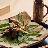 長野県飯田から生きたまま取り寄せている鮎は、串打ちをした後、炭火で焼き上げている。身体から滲み出る脂でカリッと香ばしく焼けるのも生きていればこそ。ピンと立ったひれも美しく、清流を泳ぐ姿を彷彿とさせる。