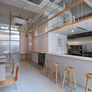 ハイスツールと手荷物用のフックを配したカウンターは、一人でも気軽に食事が楽しめます。厨房を囲んでいるので、食事をしながらピザを焼き上げる様子を眺めることができます。