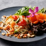 スライスした青パパイヤーをナンプラーやニンニク、ライム、ココナッツシュガー、干しエビなどと一緒にたたいて和えた一品
