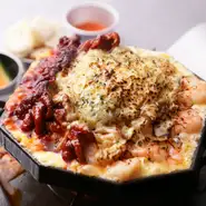 ピリ辛に炒めたイイダコとガーリックシュリンプ風に味付けしたエビにモッツァレラ、チェダー、ゴーダと3種のチーズを合わせ、鉄板とバーナーで上下から熱を加えて。ぷりっぷりの海鮮にチーズのコクがたまりません。