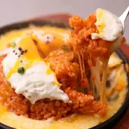 2種のチーズを敷いた鉄板に、サムギョプサルを刻み込んだ韓国キムチチャーハンをオン。『マグマキムチチーズチャーハン』は、鉄板の上でのチーズとキムチの競演を楽しめるのが魅力です。混ぜながら楽しんで。