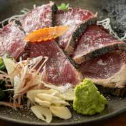 高知伝統の藁焼き製法で、一気に高温の炎をまとわせ、表面を香ばしく、中はしっとりレアに仕上げます。薬味やタレはもちろん、塩で素材の旨みを引き出す“塩タタキ”もおすすめ。