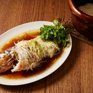 鮮魚の蒸し物は香港の代表的な料理の一つ。熱々のピーナッツ油をかけた瞬間の快音と香りが食欲をそそる。写真はアズキハタ。仕上げにかける魚のタレをかけて食べるようにと雲井窯で炊いた日本米の白飯が出る。