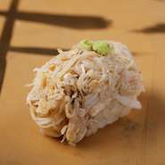 北海道や東北から届く蟹。季節や仕入れ状況により、その都度内容は変わりますが、常に鮮度の良いものを使用しています。サッと茹で上げて丁寧にほぐし、蟹味噌を和えて握りにしています。写真は『香住蟹』です。