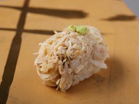 北海道や東北から届く蟹。季節や仕入れ状況により、その都度内容は変わりますが、常に鮮度の良いものを使用しています。サッと茹で上げて丁寧にほぐし、蟹味噌を和えて握りにしています。写真は『香住蟹』です。