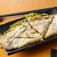 『広島風お好み焼』の特製生地を使用しているため、もちもちとした食感の中に広がる深い旨みが魅力です。中にはニラ、豚肉、キャベツがバランスよく包み込まれており、噛むほどに素材の甘みとコクがあふれます。
