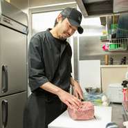 スタッフ一丸でゲストに非日常的な体験を演出する【個室焼肉　ロイヤル】。訪れる人びとの笑顔を目標に、キッチンスタッフもお肉一つ一つに想いを込めてカットしています。