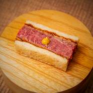 その日の特選牛シャトーブリアンを、カリっとトーストしたパンと自家製レシピのソースでサンドしました。料理人の絶妙な火入れが肉の旨みを引き出したお店自慢の逸品です。