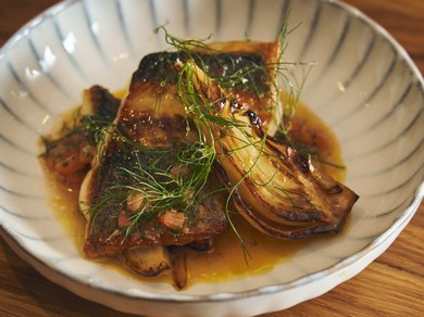 カリッと焼き上げた皮目も香ばしい『スズキのポワレ　ソース・ヴェルジュ』。焼いたウイキョウがアクセント