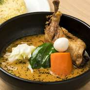 若鶏の骨付き肉を生姜と一緒にじっくり煮込み、高温の油で皮面をパリッと焼いています。野菜の甘さが豚骨ベースのオリジナルスープとの相性抜群です。スプーンで簡単に身をほぐせるホロホロ感が魅力的。