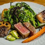 シェフの手に触れた部分からとろけていくほど融点が低い菊池源吾牛。柔らかさはもちろん、クリアな甘みのある味わいがポイント。付け合わせは、全国の生産者が作る旬の野菜を、それぞれに合った火入れでロースト。