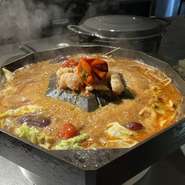 幻の尾崎牛を和牛版ジンギスカン「ワギュジスカン」で楽しんだ後に、尾崎牛の牛骨スープをベースに18種のスパイスが効いた旨辛な火鍋スープを投入します。ホルモンやきのこ盛り、そしてチャンポン麺で〆に。