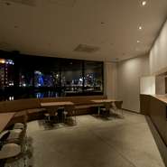 博多の屋台をイメージしたカウンターに加え、一列に並んだハイカウンターを設置。その隣には窓に面したテーブル席が広がり、ディナータイムには夜景が店内を彩ります。ほかに個室も２室あり、会食にもお勧めです。