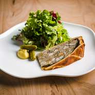 ロブションで学んだレシピをベースに古典料理を紐解き自らのレシピで作る『パテ・アン・クルート』。仔牛や豚肩肉、各スパイスを駆使した逸品で比較的あっさりした味わいに仕上げている。好みの量をカットして貰える