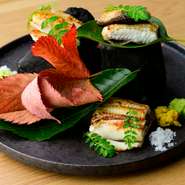 上質なうなぎを吟味し、丁寧な手仕事で仕上げる逸品。1度1秒単位での綿密な下処理を施した素材は余計な脂やクサミがなく、おいしさの純度が格別。関西風の地焼きが生む食感と風味も絶品です。夏季限定コースの逸品。