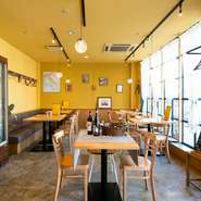 カジュアルな雰囲気の店内。温かみを演出する、薄く黄色がかった壁は、料理人がイタリア時代に訪れたお店を参考にしているとか。大きなガラス窓もまた開放感を与えてくれます。