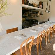 古民家をリノベーションした店内は、白を基調にしたくつろぎの空間。オープンキッチン前のカウンター席は、千葉さんが調理する様子を間近に見られる特等席。おいしい音と香りに包まれ、至福の時間を過ごせます。