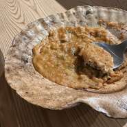 青森の郷土料理。大きなホタテの貝殻の上で卵と味噌をとき、貝殻からでる自然の出汁と混ざり合います。