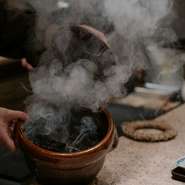 コースの締めにふさわしいご飯。炎が立ち上る薪を釜に入れ、香りづけをする豪快な仕上げは、見る者を魅了します。芳醇な香りと絶妙な味わいが食欲をそそり、一度食べたらまた味わいたくなる逸品です。