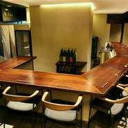 駅前の雑居ビルにありながら、想定外のスタイリッシュな雰囲気に意表をつかれる店内は、14席のダイナミックなカウンター席がメイン。無機質な空間の中、木の温かみが伝わります。奥には個室もあり。