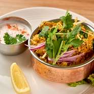 “世界の三大炊き込みご飯”の一つとしても知られるビリヤニ。インドの高級米・バスマティライスを数種類のスパイスで味付けした、風味豊かな逸品です。ヨーグルトを使用したサラダ（ライタ）もセットで楽しめます。