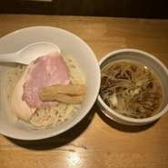 やや濃い目の醤油だれを丸鶏の極上スープで割ったつゆと、もちもちした平麺の組み合わせがクセになる一杯。トッピングは中華そばと同じく、しっとりとやわらかい高級鶏ムネ肉と豚肩ロースのチャーシュー2種です。