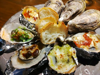 新鮮な牡蠣を殻ごと焼いて、さまざまな味わいで楽しむ。シェフこだわりの看板メニュー『グリルオイスター』