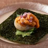 有明海の海苔に炙った帆立と雲丹をのせて巻いていただく逸品。塩で味付けされた香ばしい帆立と、とろけるような雲丹が絶妙なハーモニーを奏でます。海の恵みを存分に味わえる、口福のひとときです。