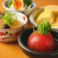 テーブルを彩るおばんざい料理も自慢。自慢のお出汁を使用した「お出汁ひたひたトマト」や「お出汁たっぷりしみ大根」おかかこだわりのお出汁でつくる「出汁巻き玉子」鹿児島県産黒豚を使用した「自家製メンチ」。