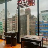 街の賑わいと共に観覧車やビル群を望むことができる、ガラス張りの大きな窓。歩道や道路の様子まで見渡せて、まるで都市のリズムを上から感じ取っているかのようです。