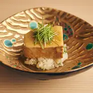 鮨店の肴の定番的存在のあん肝を、蒸し寿司風にアレンジ。従来の味つけはそのままに甘さを控えめにしたあん肝は、有馬山椒を加えることであっさりとした後口に。鮨飯にも木の芽を混ぜ爽やかな風味を演出しています。