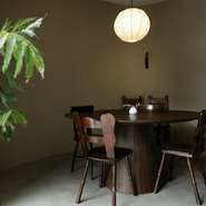 キッチンから目の行き届く適度な仕切りで、ゆったりとした作りの半個室。スタイリッシュな雰囲気ながらアンティークテーブルや植物を配し、温かみのある空間。昼間は柔らかな自然光、夜は路地の薄明かりが心地よい。