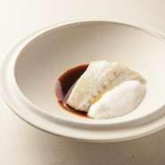 1〜2週間熟成させ、プリッと弾力を増したサメカレイと、オマール海老、ハマグリ、イカ、ムール貝からそれぞれだしをとり、絶妙なバランスで合わせた後に煮詰めたソースに、バニラの泡を合わせています。