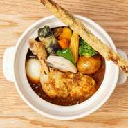 こだわりのだしに珈琲と麹を加えた、深いコクと味わいのあるクラフトスパイススープ。そのスープをベースに、塩麹で漬けこんでから煮込んだ、やわらかい鶏のレッグとたっぷり野菜の定番スープカレーです。　