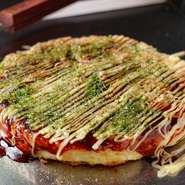オシャレな空間で、名物のお好み焼きや、焼きそばといったアツアツの鉄板料理を楽しめる【粉もん處　光圀　裏なんば店】。デートや記念日、宴会と幅広いシーンに利用できるお店です。