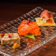 右は、自家製ママレードとエポワスに生ハムを被せ、甘みと塩気の見事なハーモニーを奏でるカナッペです。中央は、旬の鮮魚を使ったカルパッチョ。左の神戸ポークのパテは、スパイスで香り高く仕上げています。