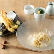 看板メニューである素麺は、独自のブレンドでつくられた自家製のつけ汁も自慢です。鰹節や昆布をベースにしただしの濃厚な味わいを堪能できます。写真は、定番メニューの『天ぷらのそうめん（冷）』。