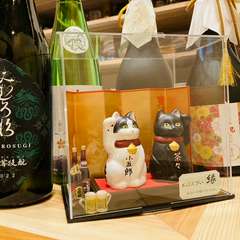 飼い猫を描写した招き猫と日本酒の一部