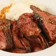 赤身肉を低温調理で焼き上げた、やわらかなステーキをライスとボリュームたっぷりに。たまねぎのステーキソースと別添えの山ワサビソース、お好みで2種の味わいを楽しめます。肉の旨みたっぷり！
