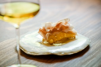 熱々の揚げパンの上に薄くスライスした【ボッテガパルコフィエラ】の生ハムをのせた『トルタフリッタ』