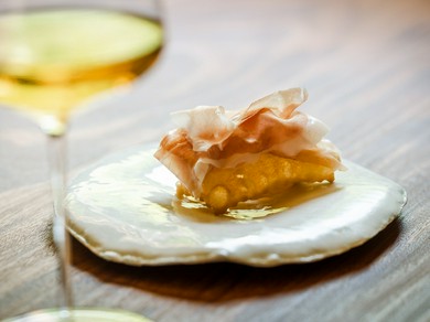 熱々の揚げパンの上に薄くスライスした【ボッテガパルコフィエラ】の生ハムをのせた『トルタフリッタ』